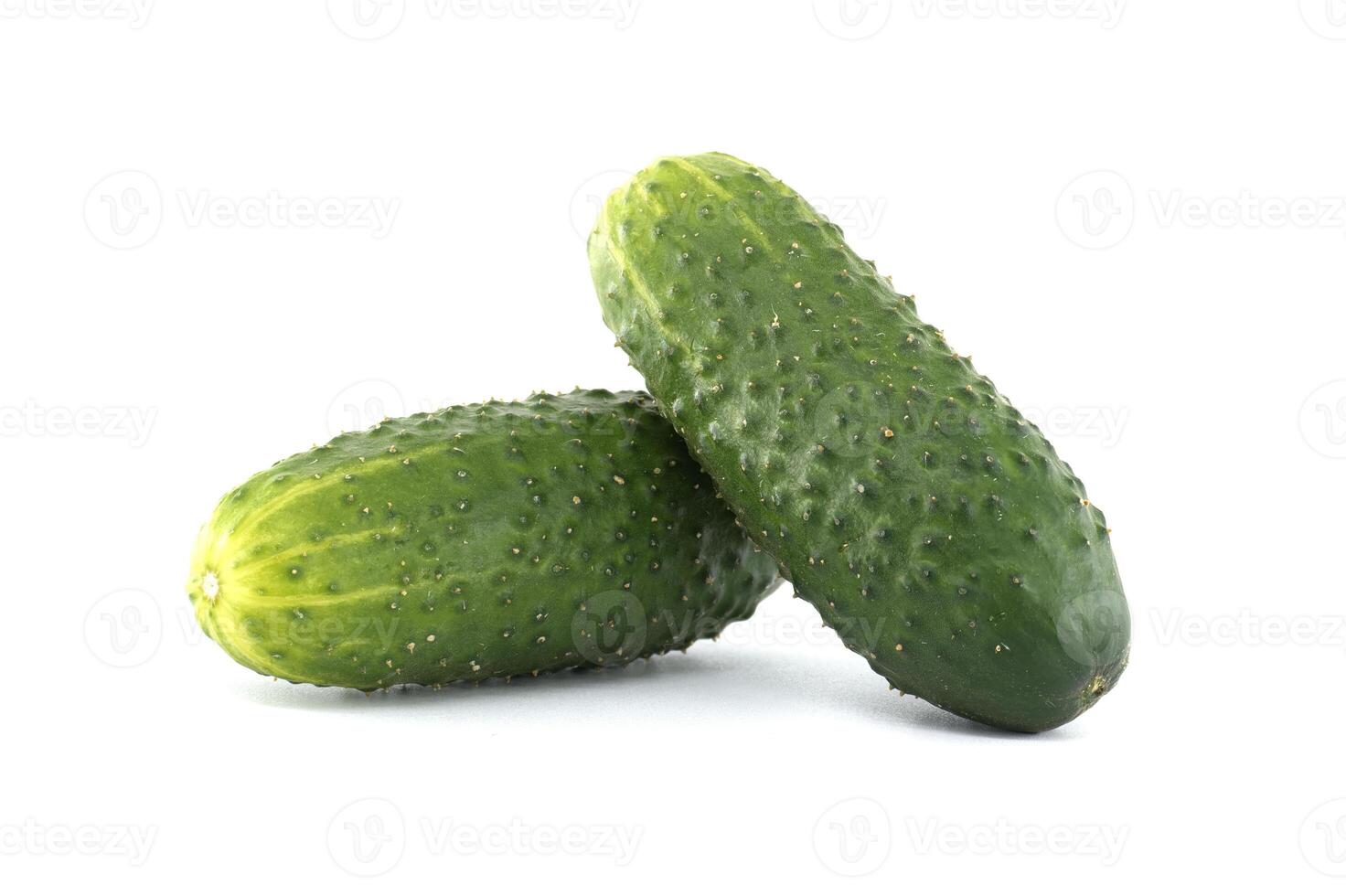 Two vibrant green cucumbers, showcasing their freshness and texture on a bright white backdrop. photo