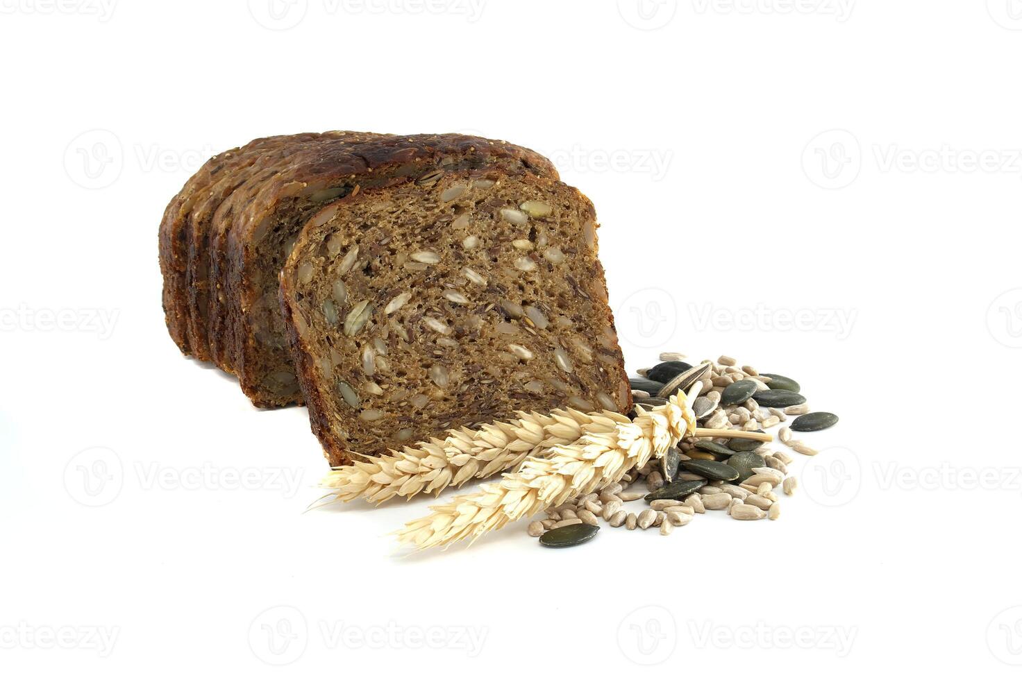 A sliced loaf of dark rye bread with mixed seeds and wheat stalks arranged on a white background. photo