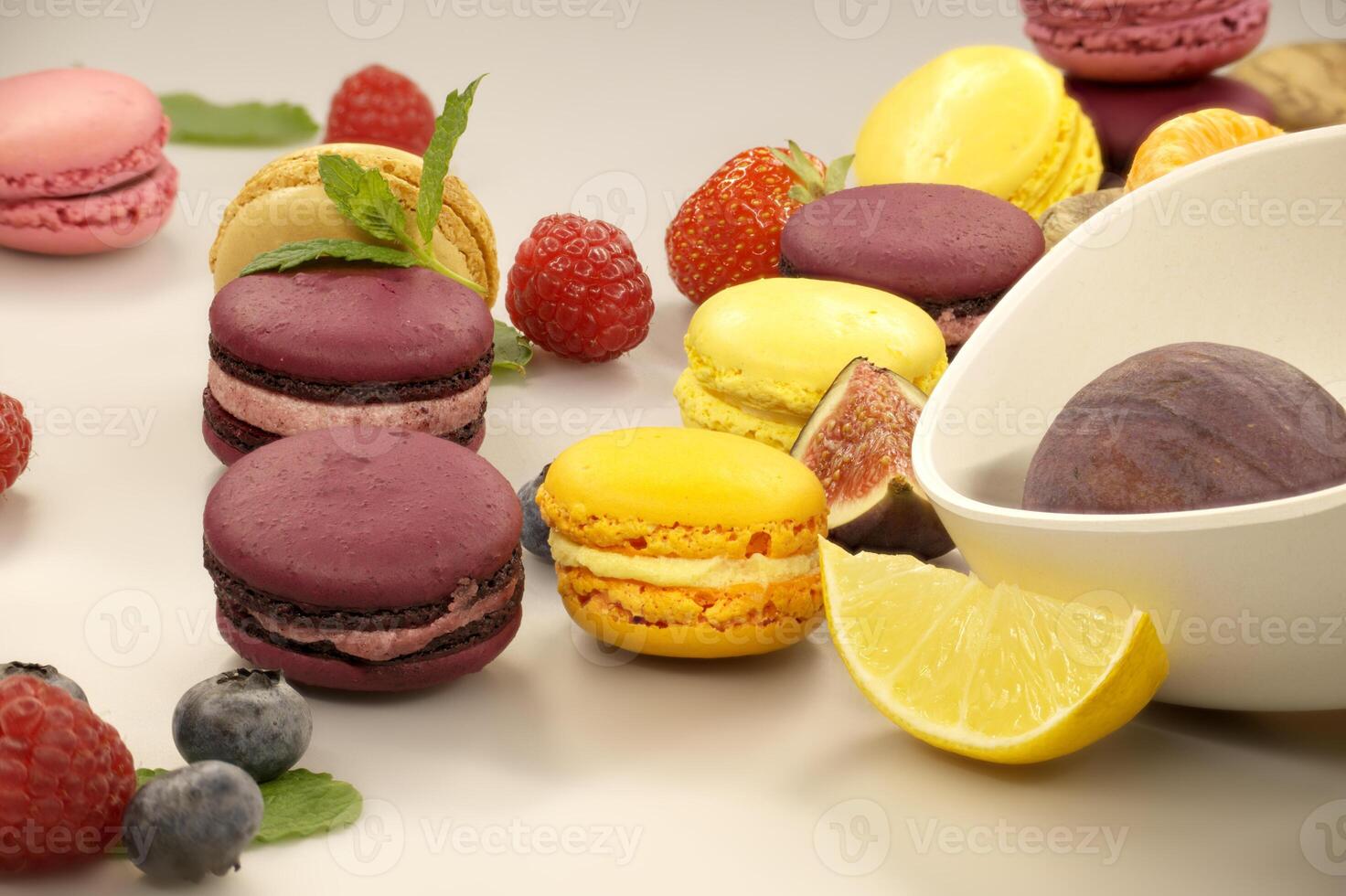Table filled with macaroons and fruits. photo