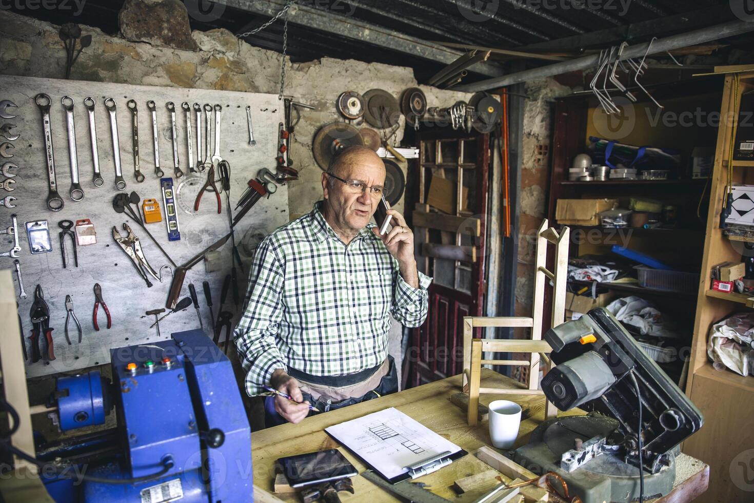 Carpenter with phone in his workshop photo