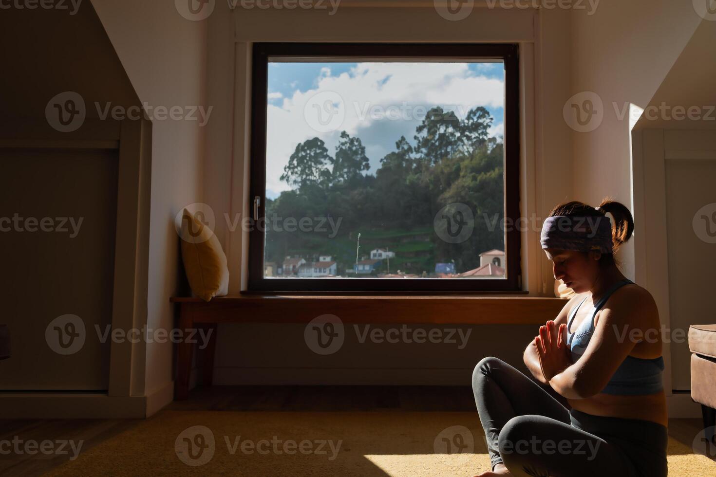 Woman Practicing Yoga in Front of Window photo