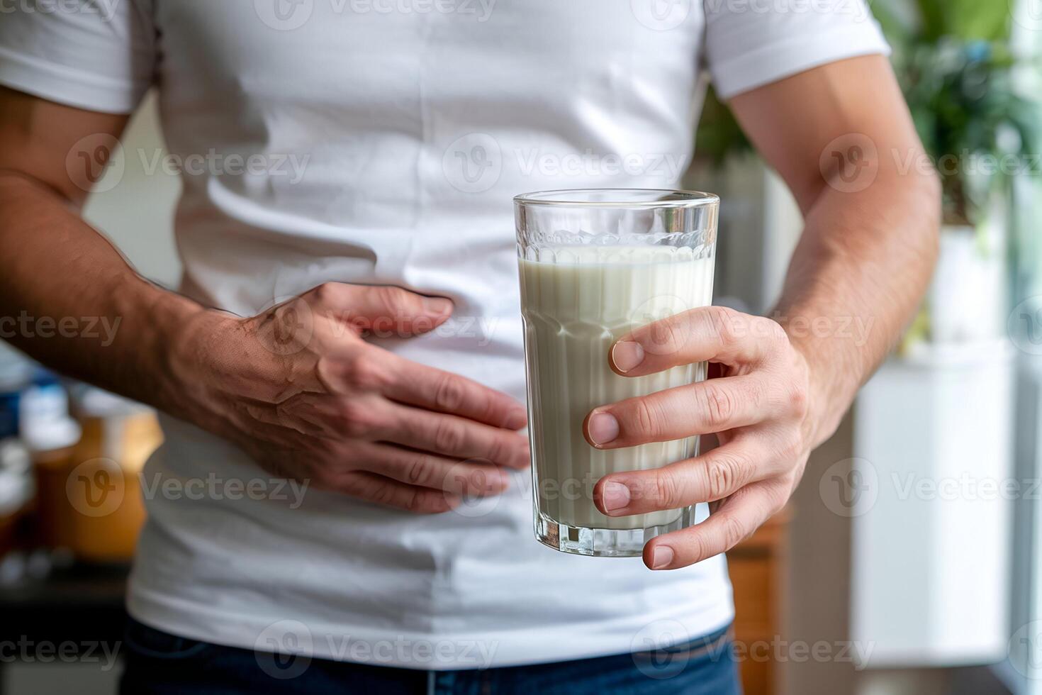 Hand holding milk glass, other on stomach photo