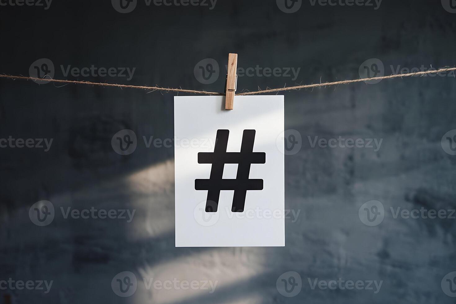 White hashtag card on twine against dark gray background photo