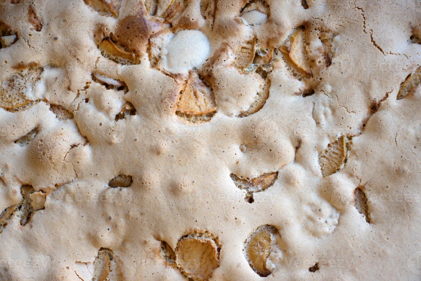 Detailed closeup top view of a freshly baked homemade apple pie texture with apple slices and golden crust. 01 photo