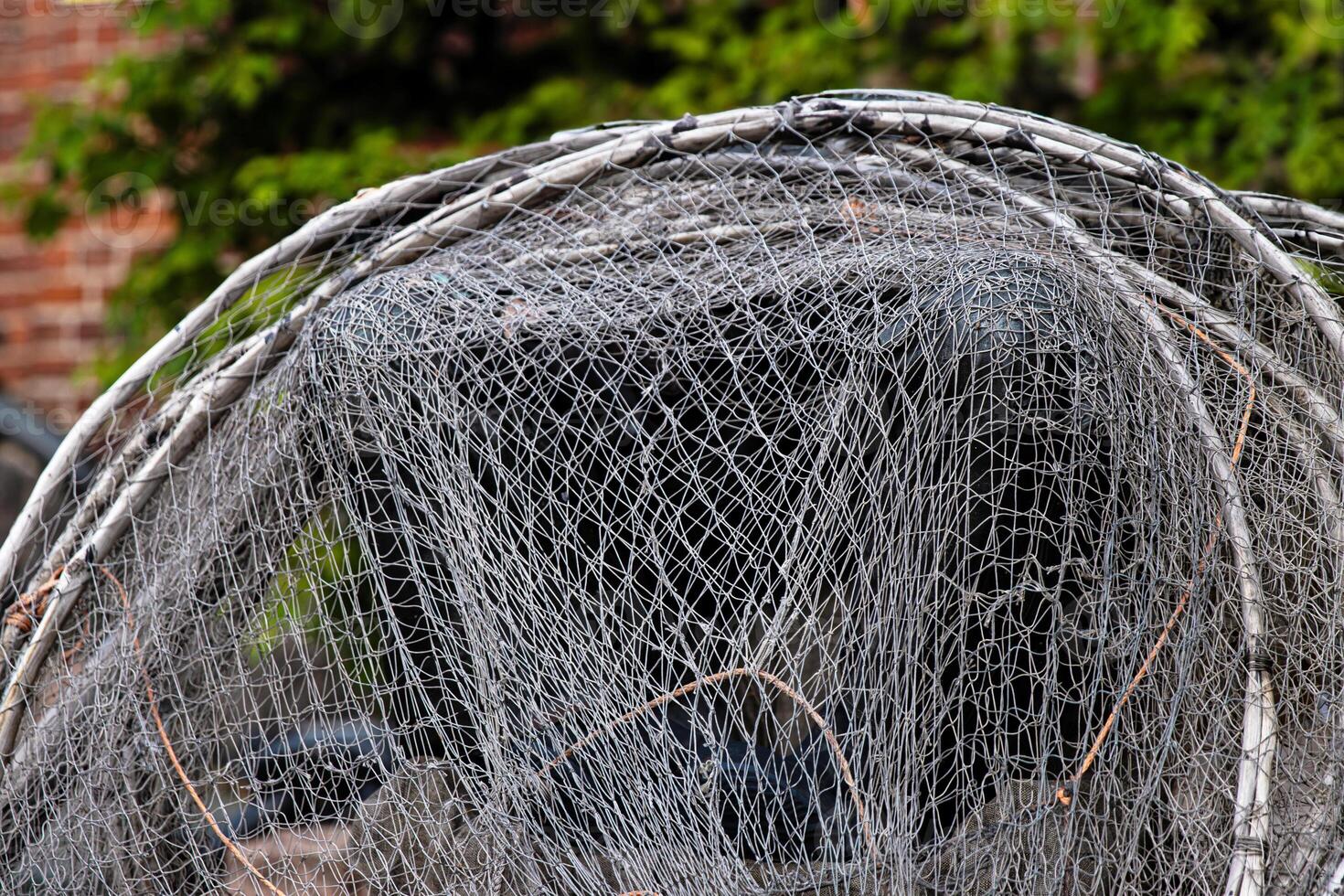 Fisher equipment. A weathered folded fishing hoop net and coiled wire and ropes on the ground, 13 photo