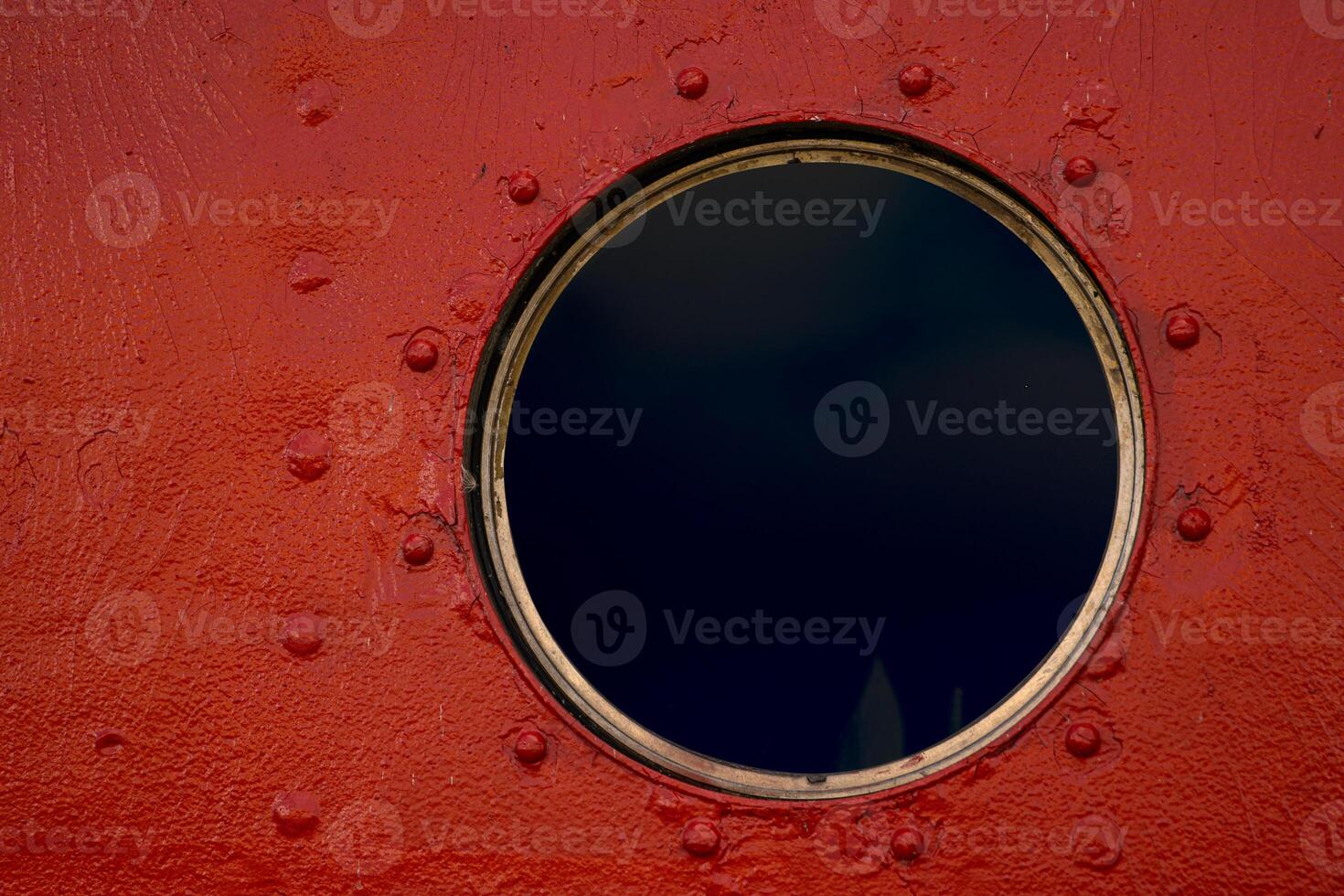 A detailed closeup of a round porthole with a protective glass on the brown painted old boat wall. Brooms are stored inside 09 photo