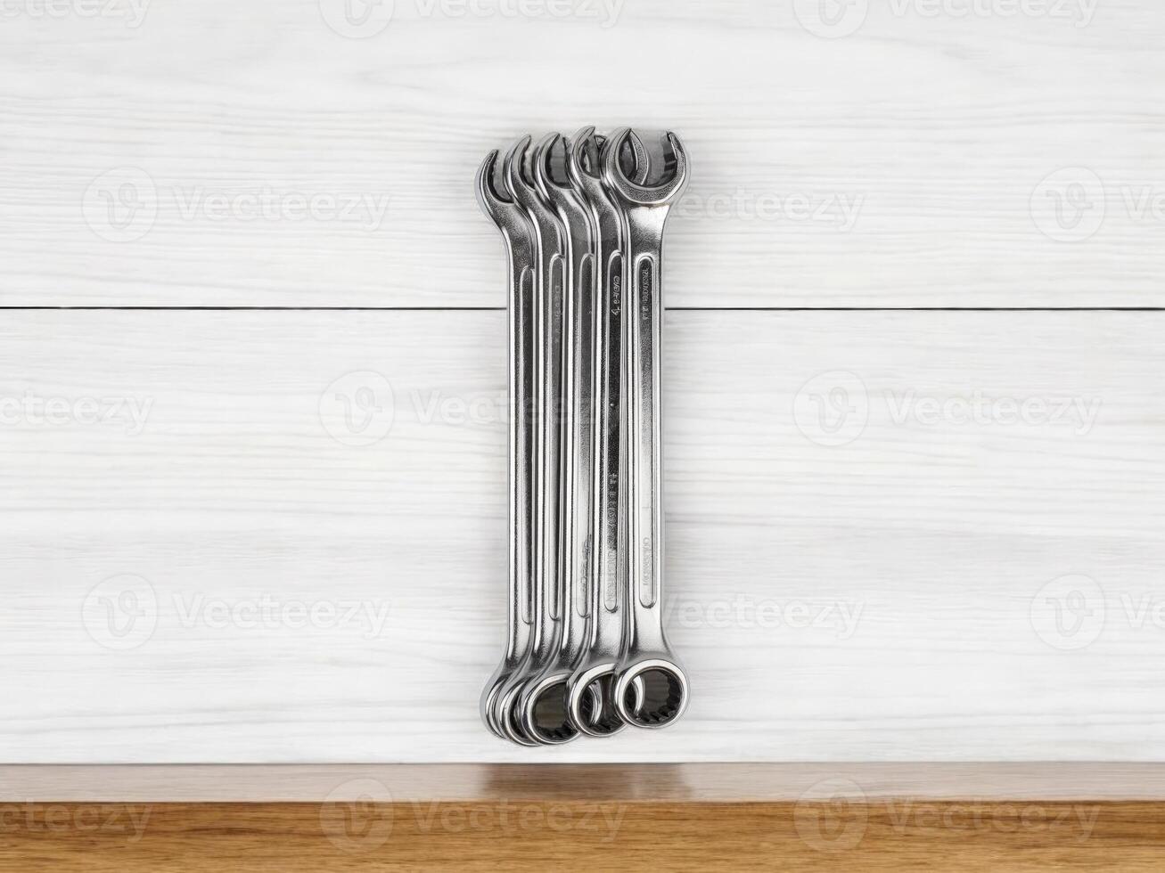 A meticulously arranged set of spanners on white wooden surface, radiating sense of neatness and preparedness photo
