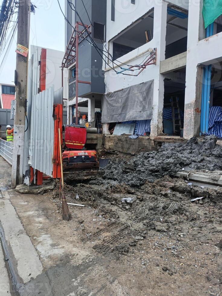 An excavator performs excavation work with unwavering determination, showing strength and precision in urban landscape photo