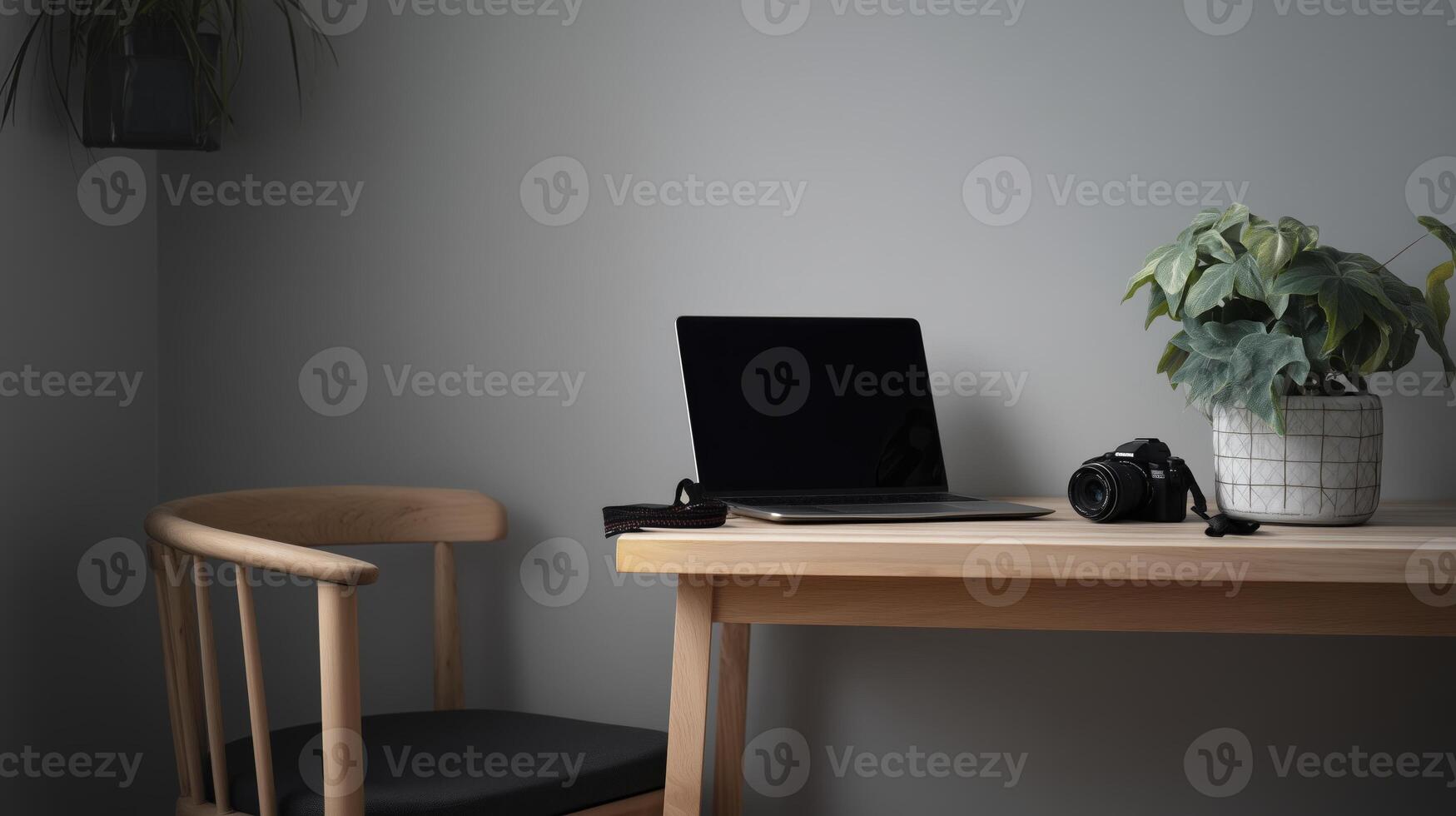 Simple wooden desk with open laptop, camera, and potted plant creates minimalist workspace. neutral tones and natural light evoke calm and focused atmosphere photo