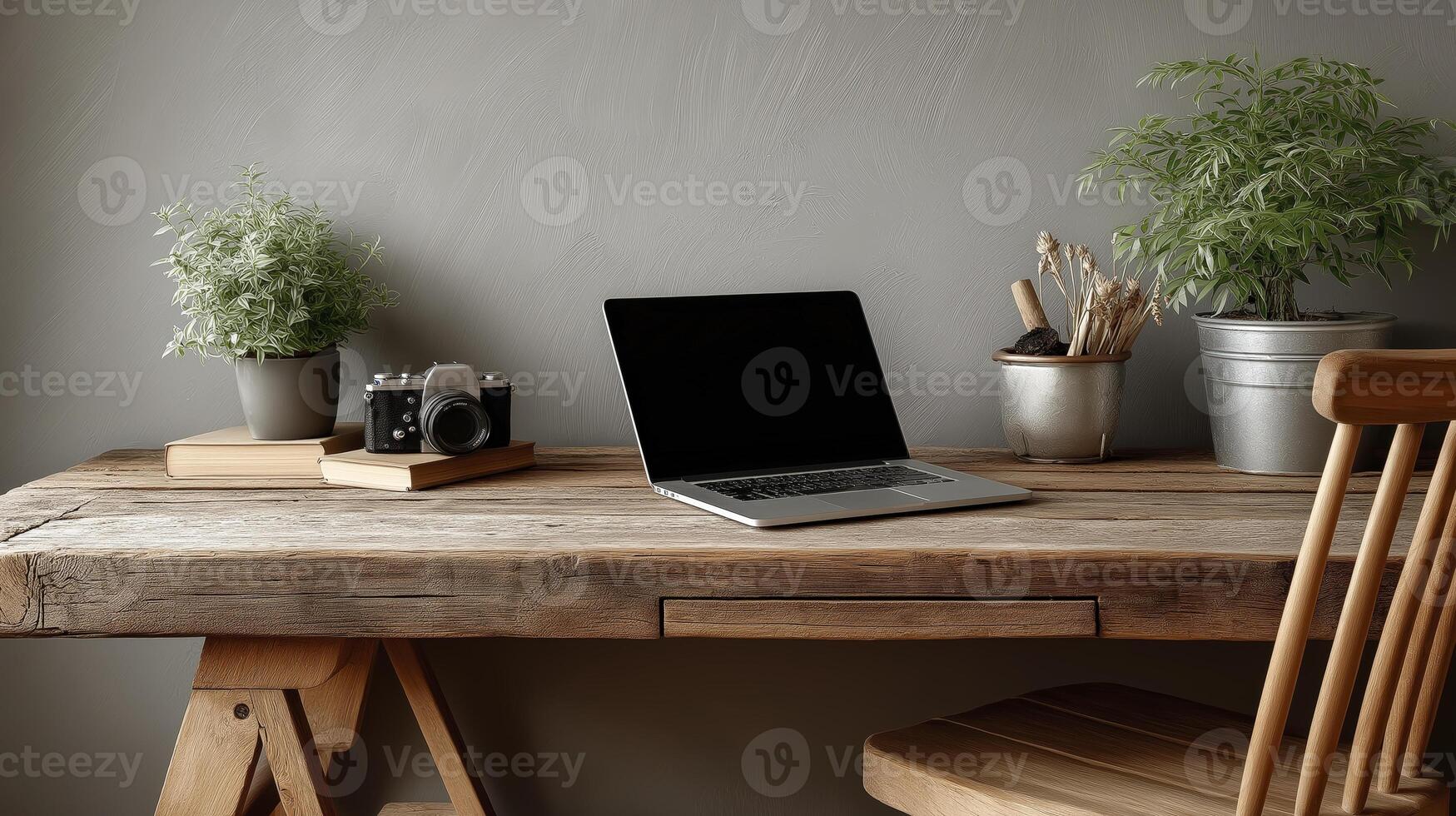 Simple wooden desk with open laptop, vintage camera, and potted plants creates serene workspace. natural wood and greenery add calming touch to minimalist setup photo