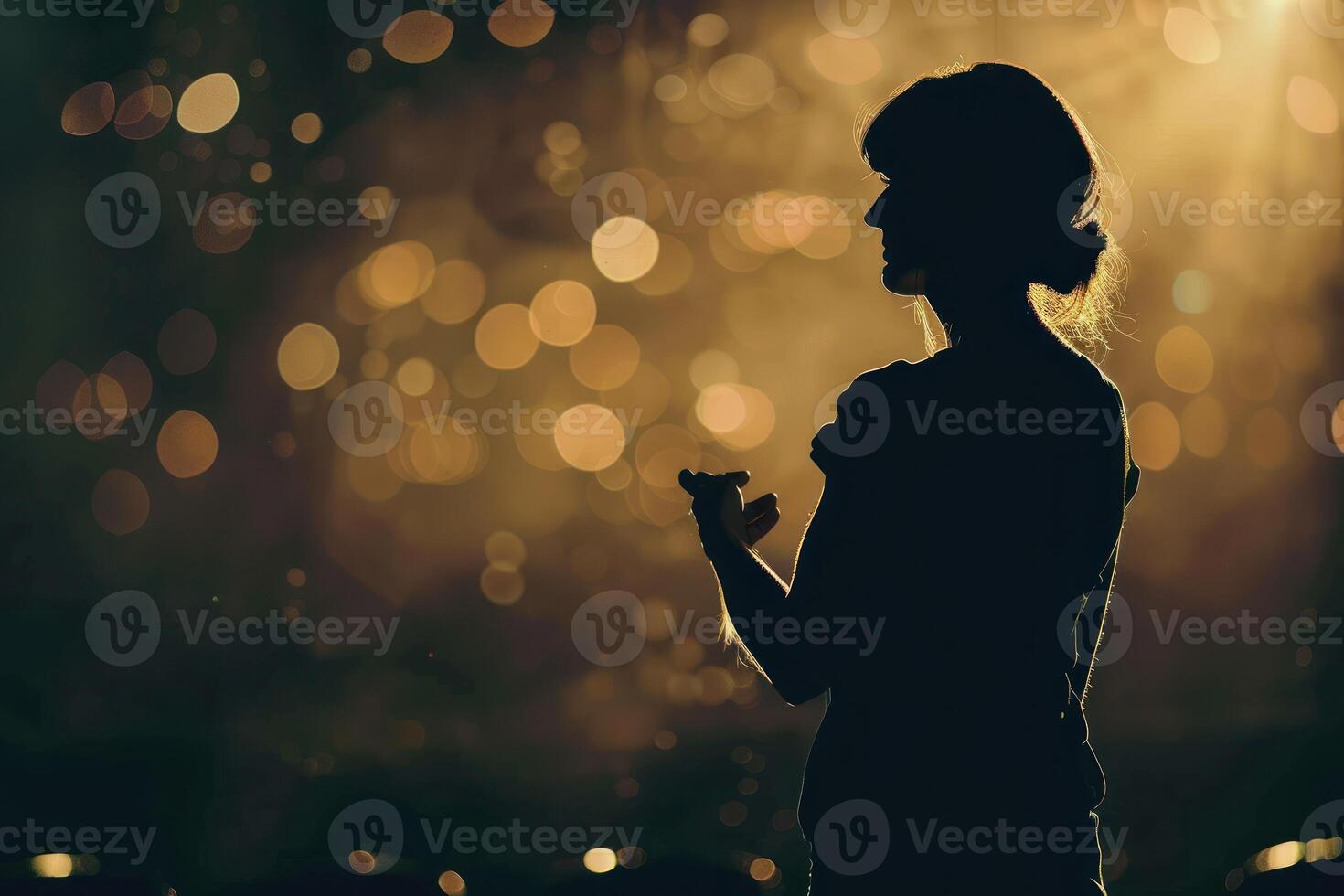 Silhouette of a woman standing in front of a stage photo
