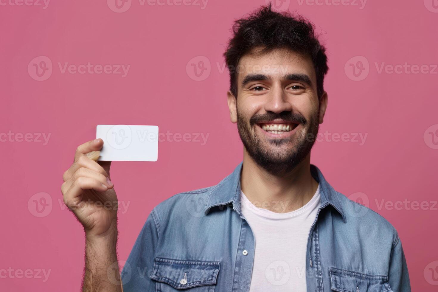 A man holding up a blank card against a pink background photo