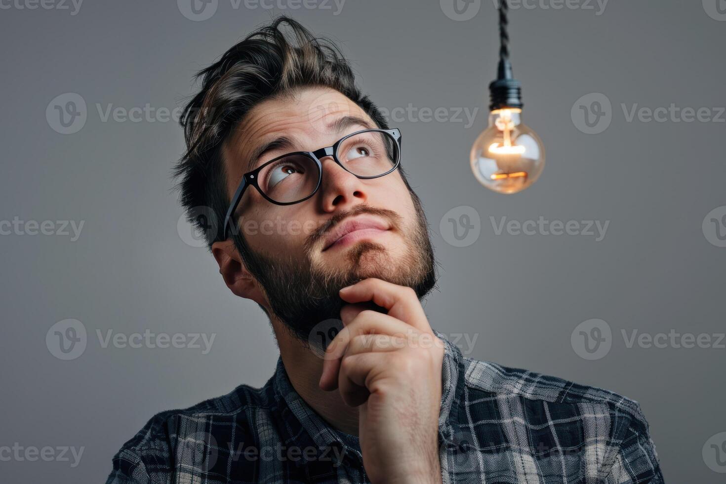 A man with glasses and a beard is thinking about something photo