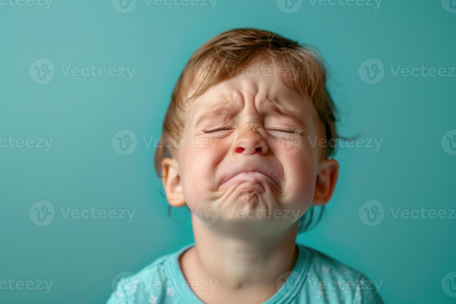 A little girl with her eyes closed and a sad expression photo