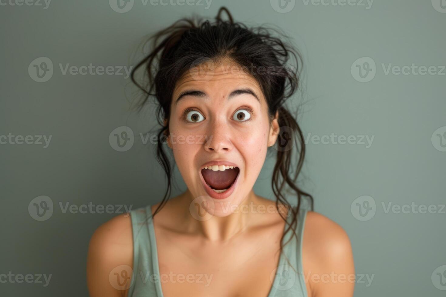 A woman is making a surprised face while looking at the camera photo