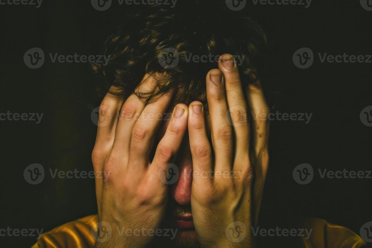 A man covering his face with his hands photo
