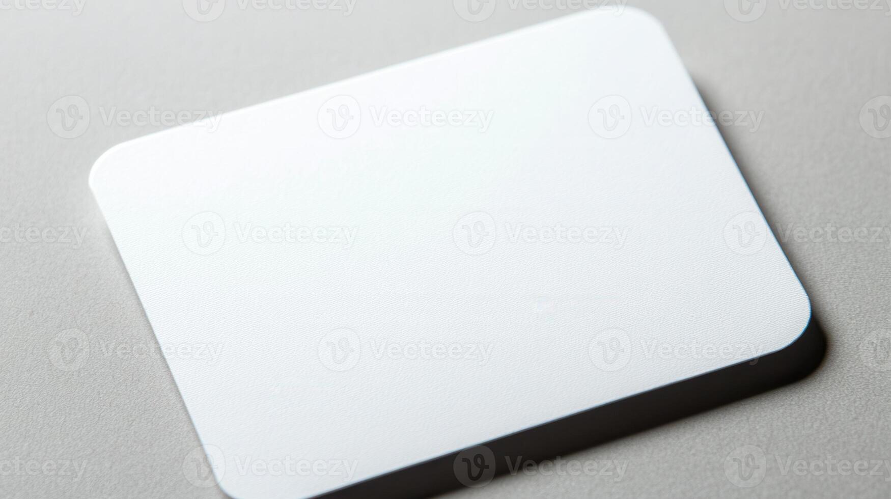 A white square mouse pad on a gray surface photo