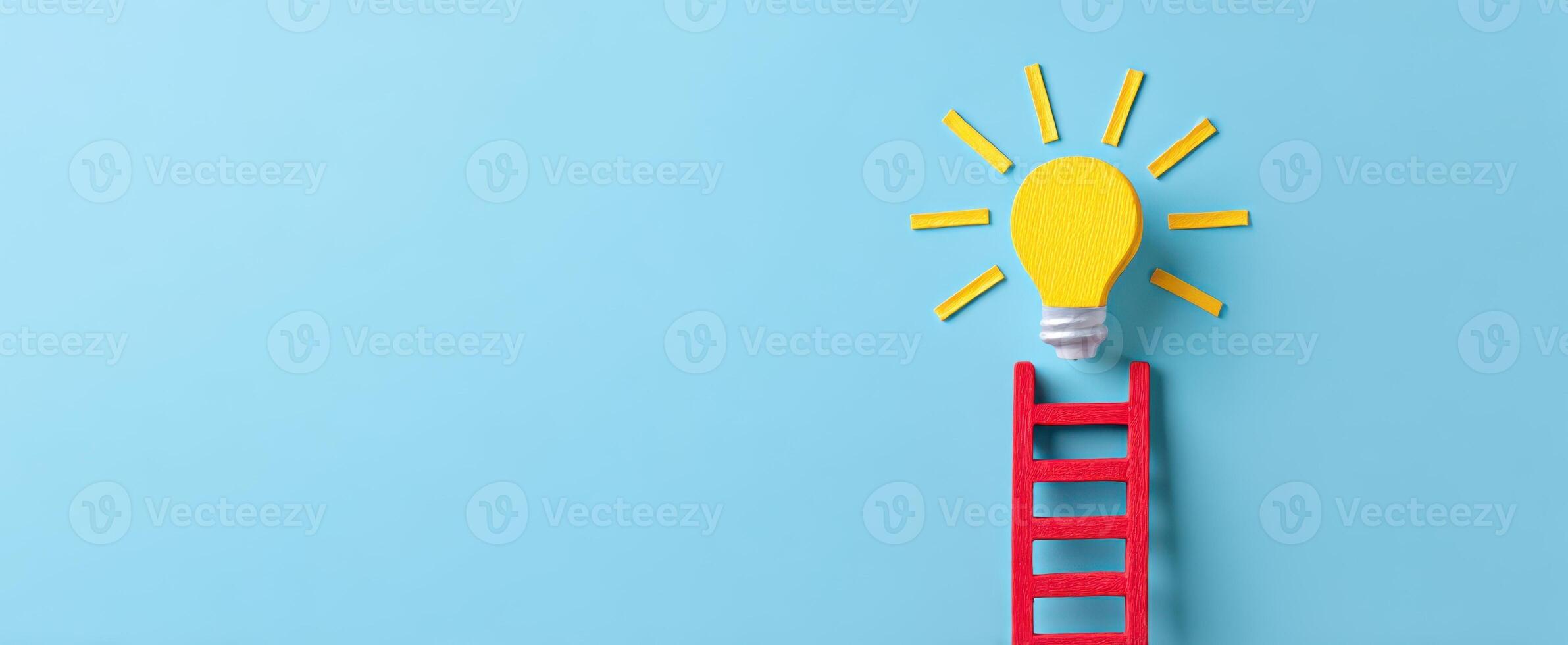 The light bulb atop a colorful ladder symbolizes creative innovation and inspiration. photo