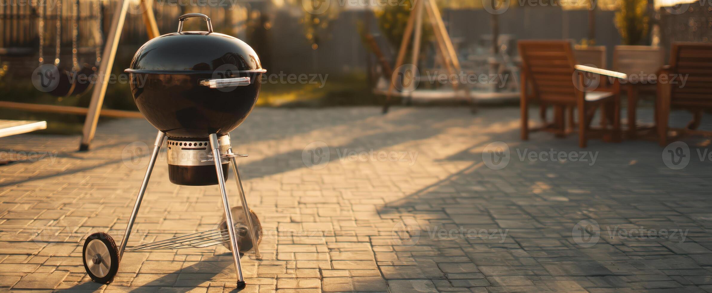 The sleek charcoal grill ready for a summer barbecue in a sunny backyard setting. photo