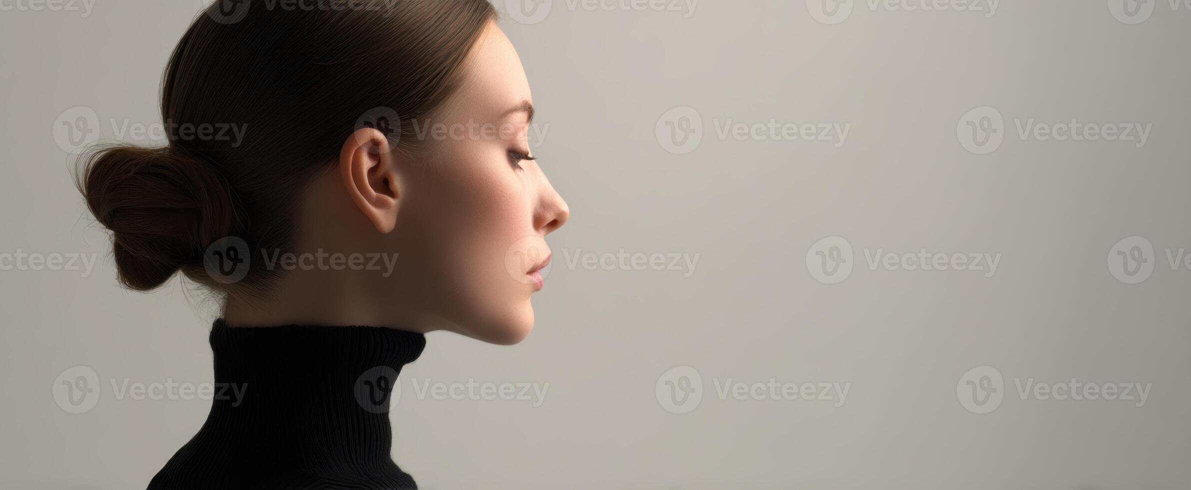 The elegant profile of a woman in a minimalist studio setting. photo