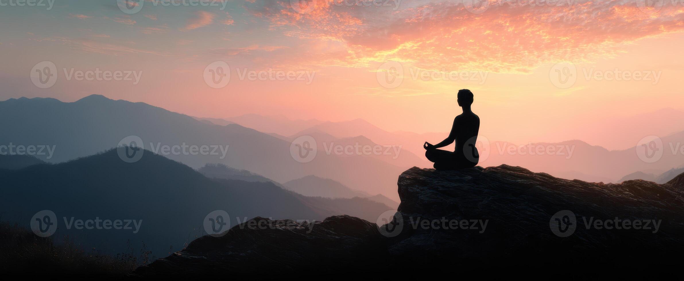 The silhouette of a meditator enjoying a serene sunset in the mountains. photo