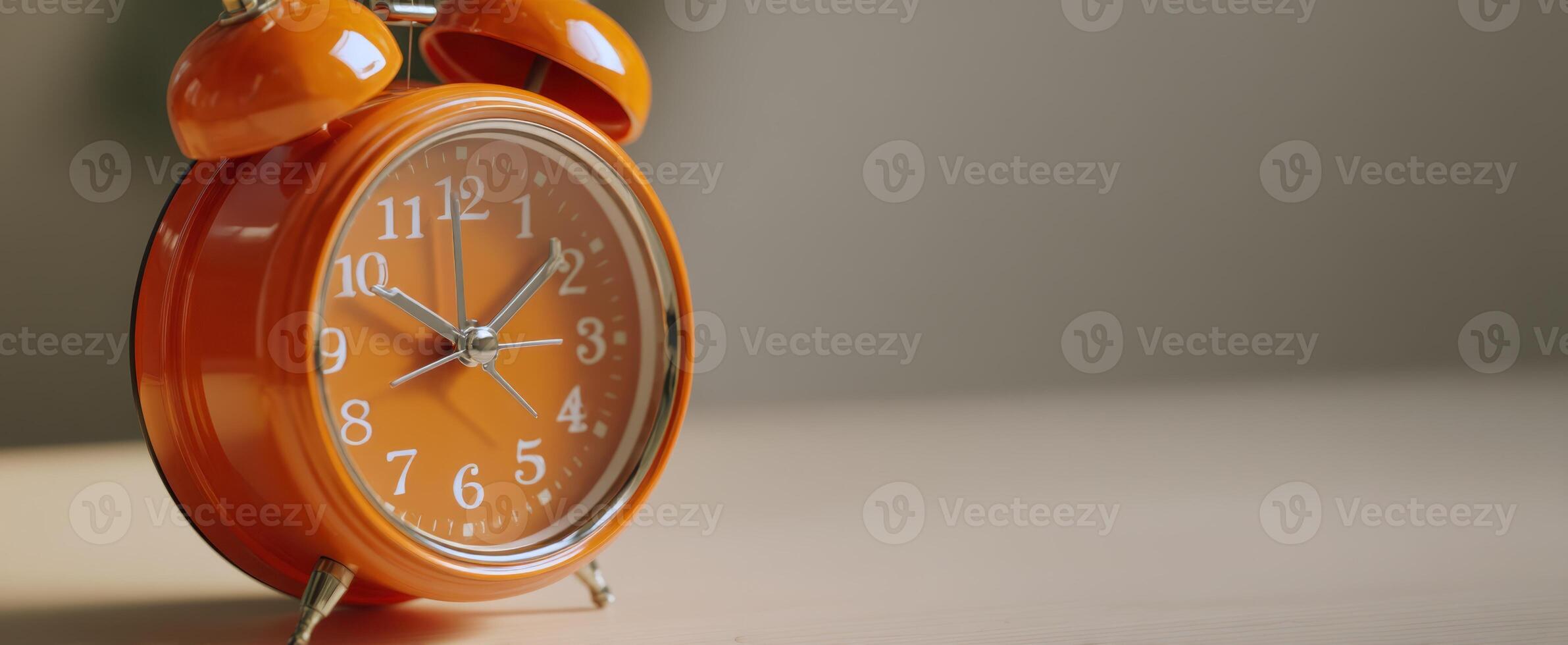 The vibrant orange alarm clock on a wooden surface radiating warmth and nostalgia. photo