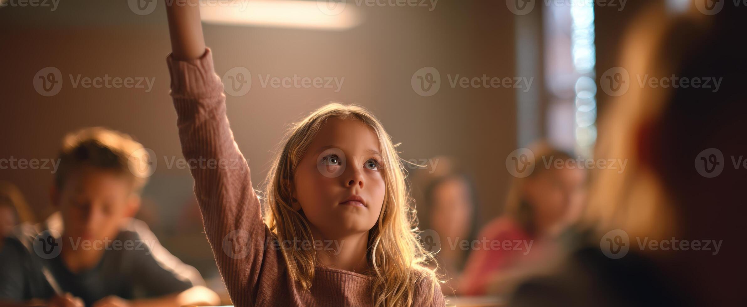 The girl in the classroom eagerly raising her hand for a question. photo