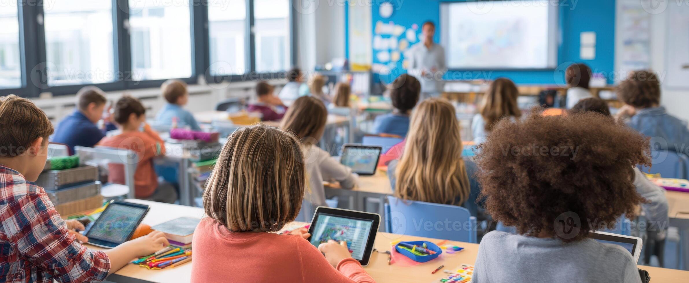 The classroom filled with engaged students using tablets for learning activities. photo