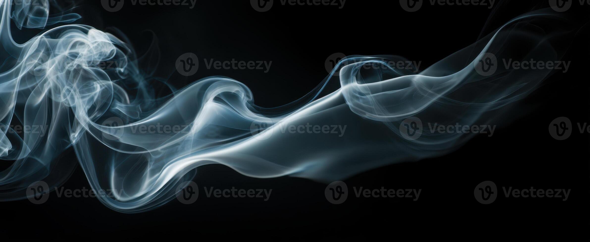 The swirling smoke creating an ethereal and abstract composition on a black background. photo