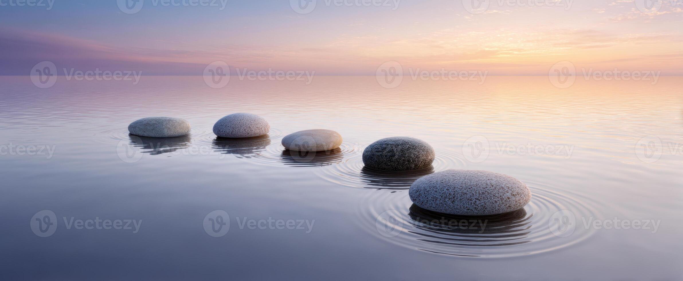 The tranquil stones creating ripples in a serene water landscape at sunset. photo