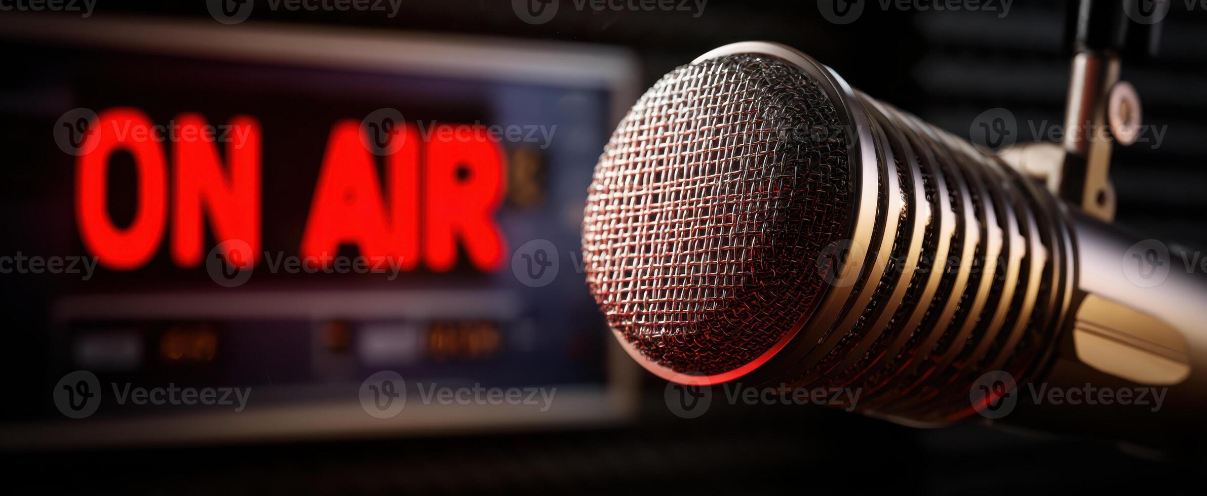 The vintage microphone in front of an illuminated 'ON AIR' sign. photo