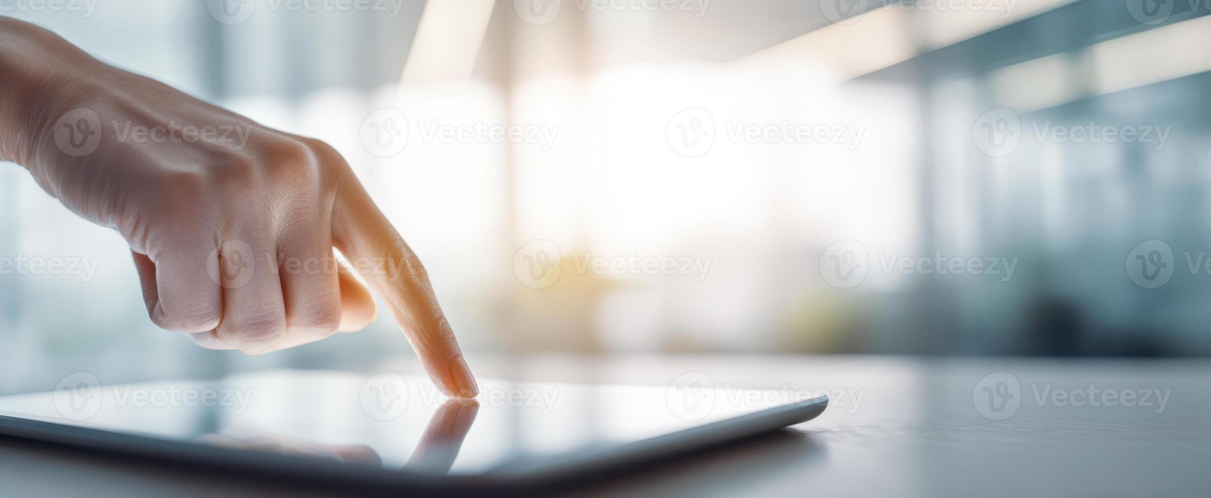 The hand gently touching a tablet screen in a modern office environment. photo