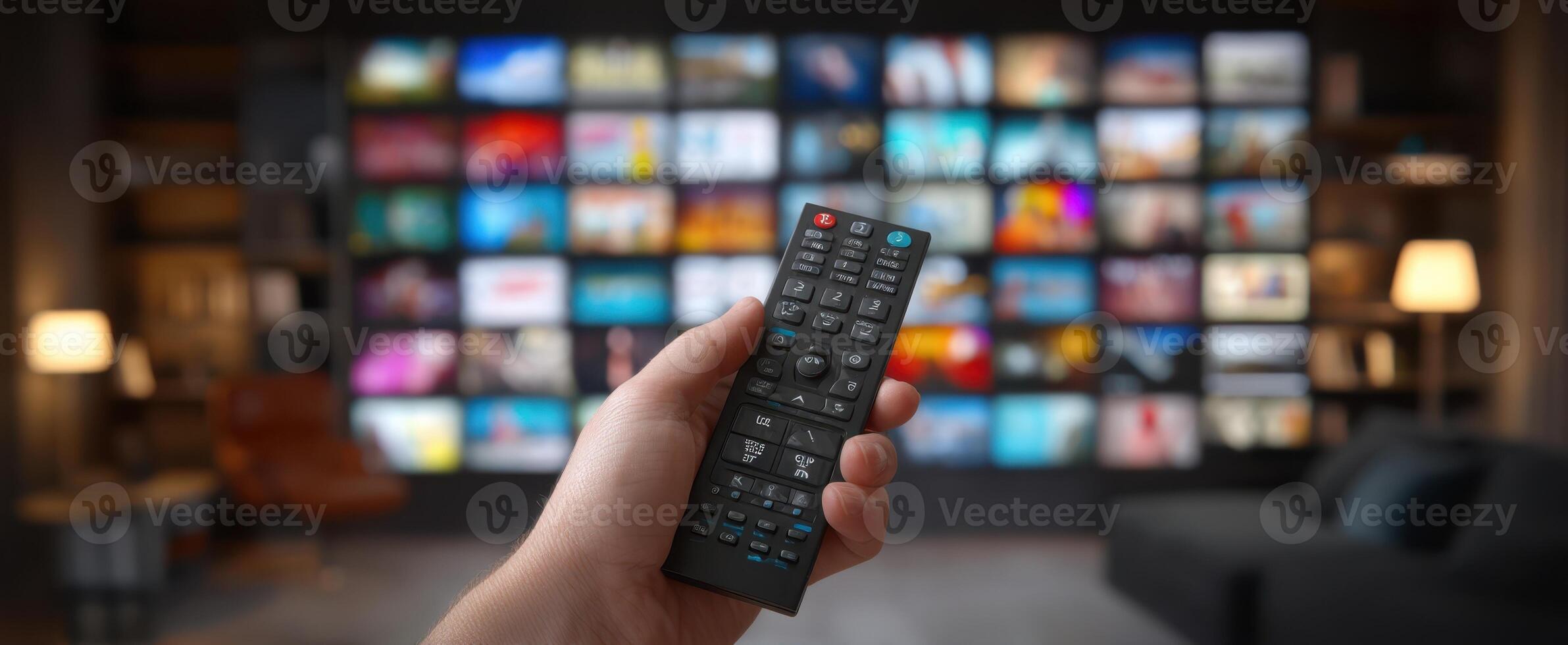 A person holding a remote control in front of a television screen photo