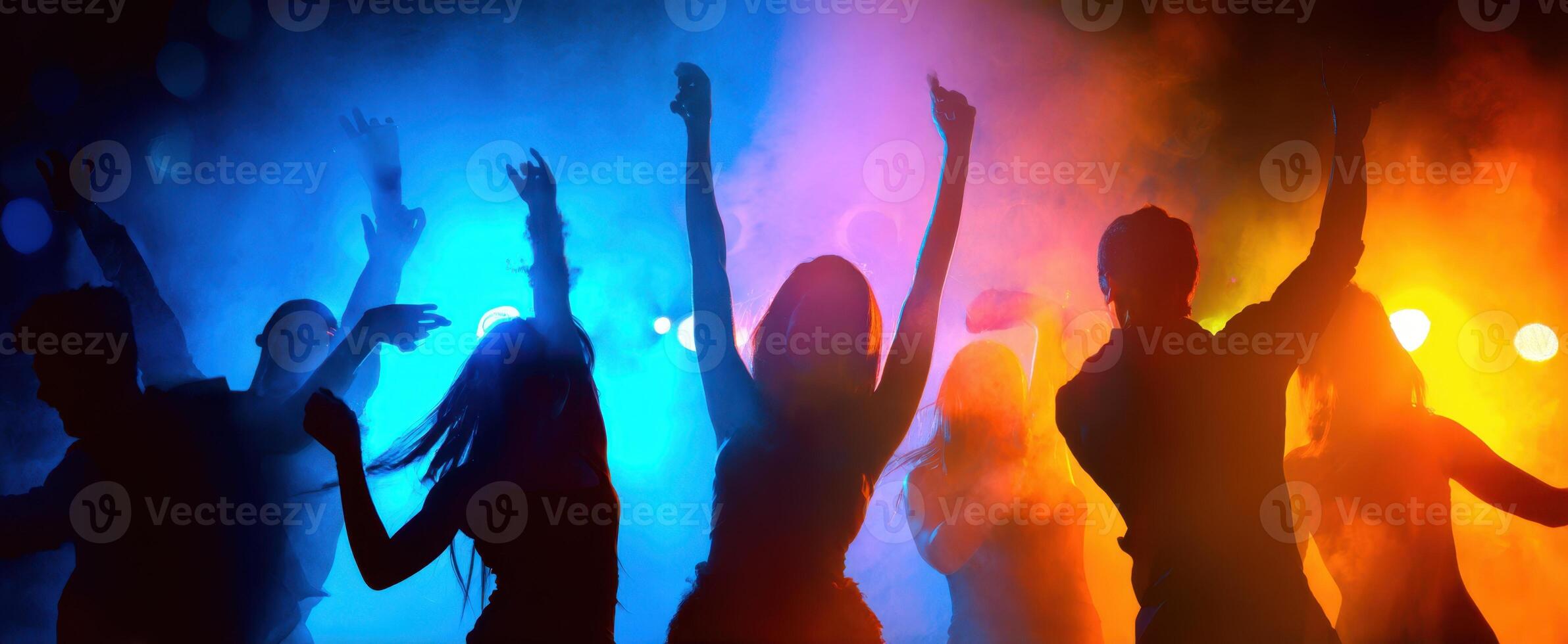 The energetic dancers silhouetted against colorful lights and smoke at a lively party. photo