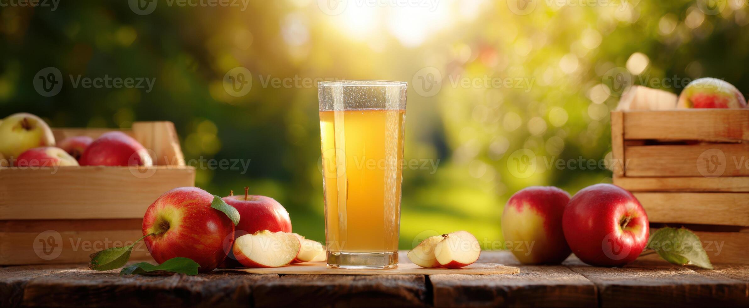 The refreshing apple juice served in a glass surrounded by fresh apples. photo