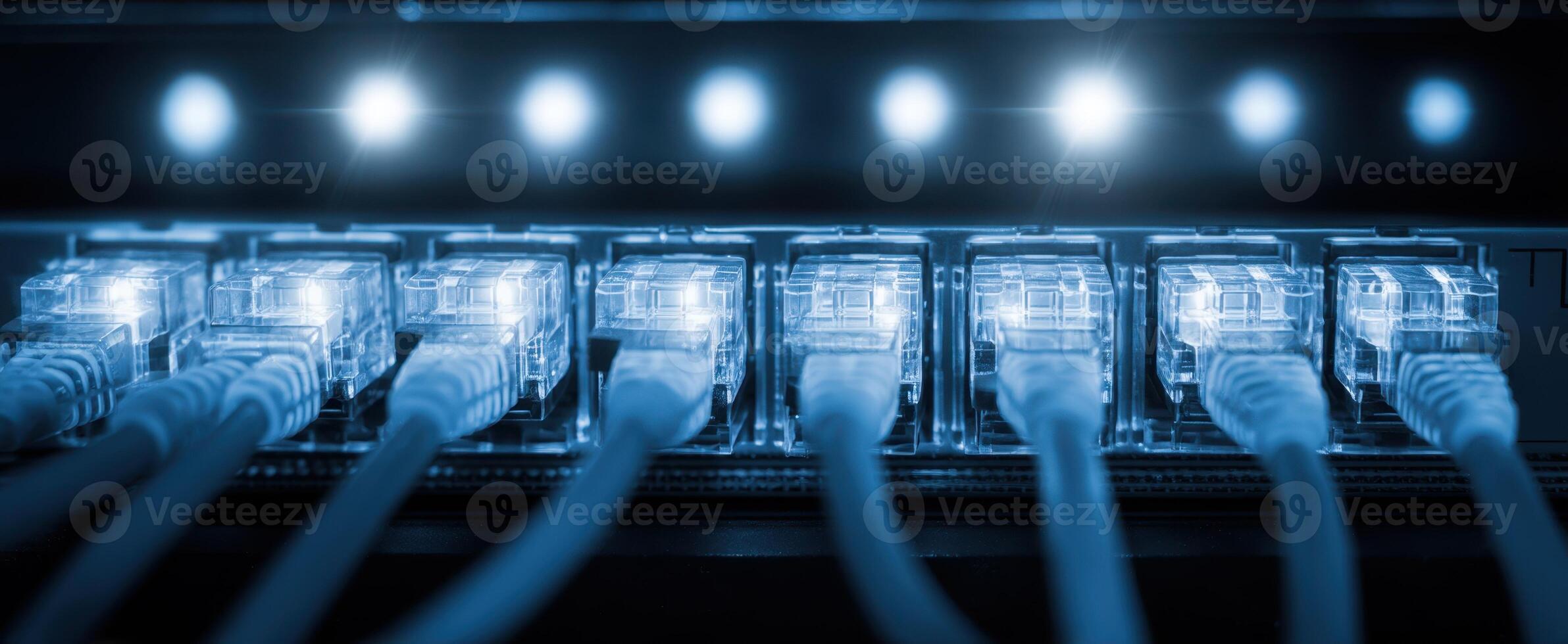 The Ethernet cables connected to a modern networking device glowing in blue light. photo
