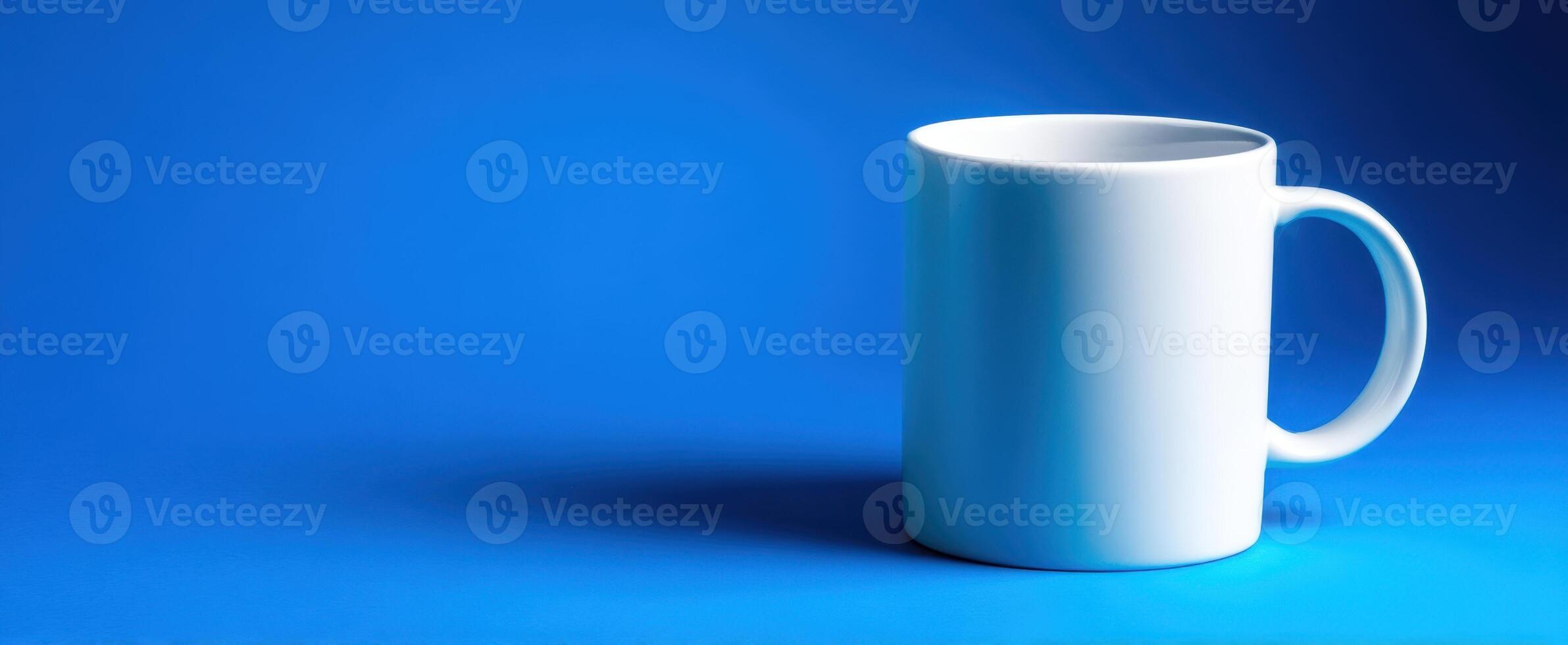 The elegant white mug on a vibrant blue background for perfect branding. photo