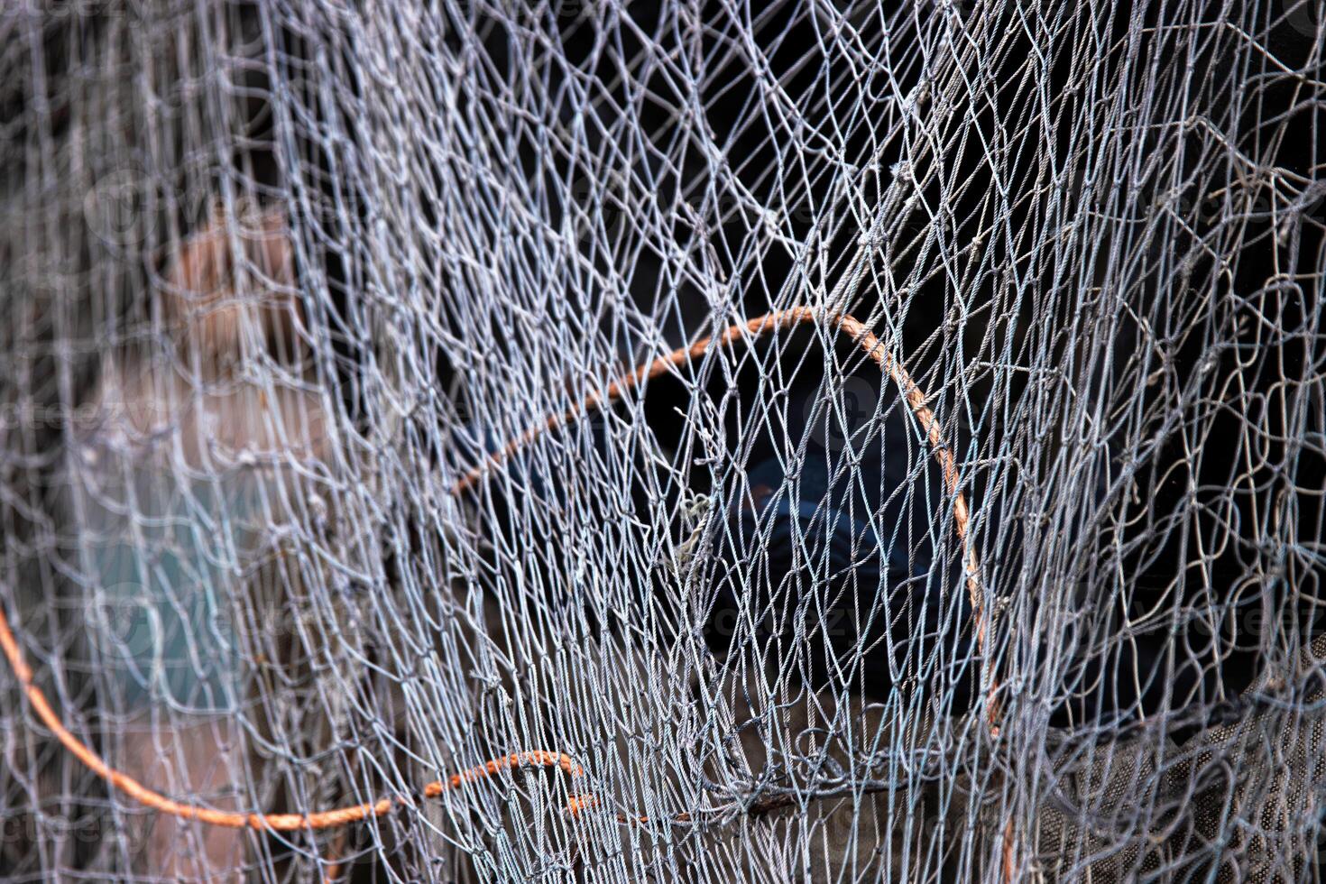 Fisher equipment. A weathered folded fishing hoop net and coiled wire and ropes on the ground, 07 photo