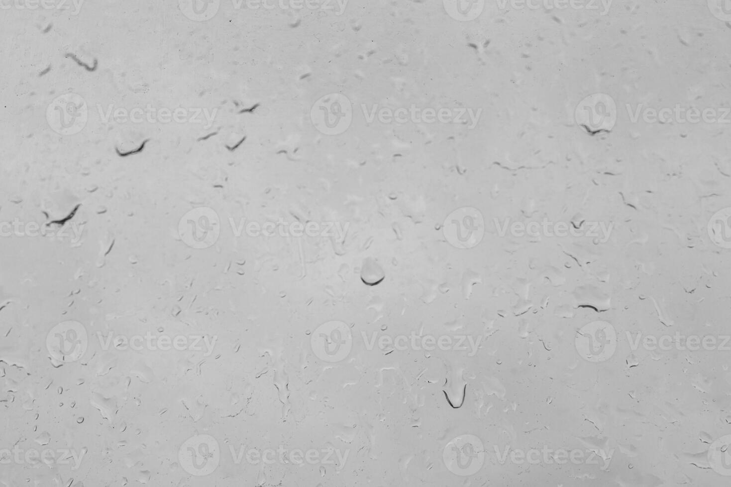 Rain drops on a window create a natural texture. Transparent liquid element for background or overlay effect concept on a gray surface. photo