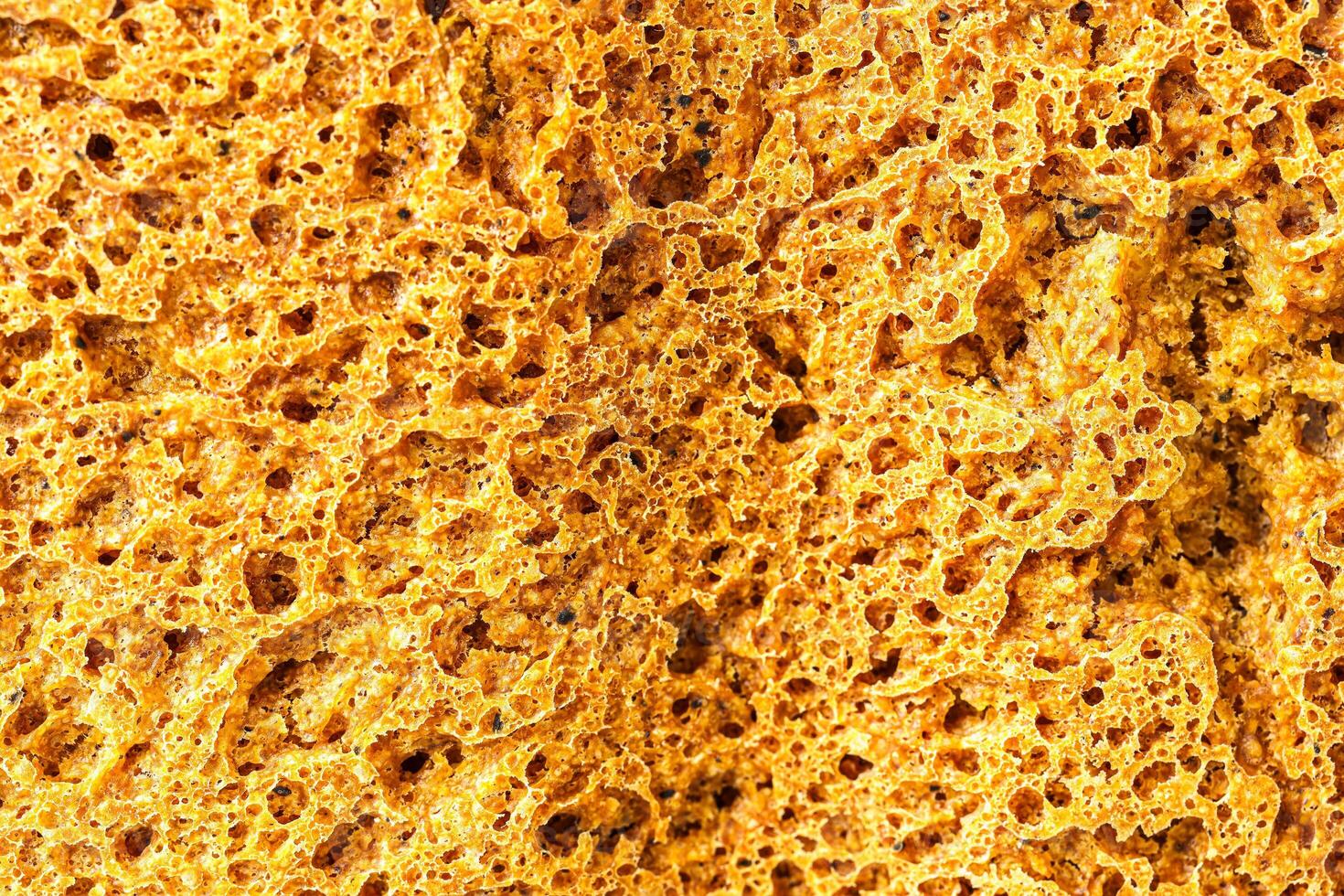 Detailed macro of wholesome whole grain bread texture showing the porous crust of rye country homemade bread, a baking sweet abstract background. photo