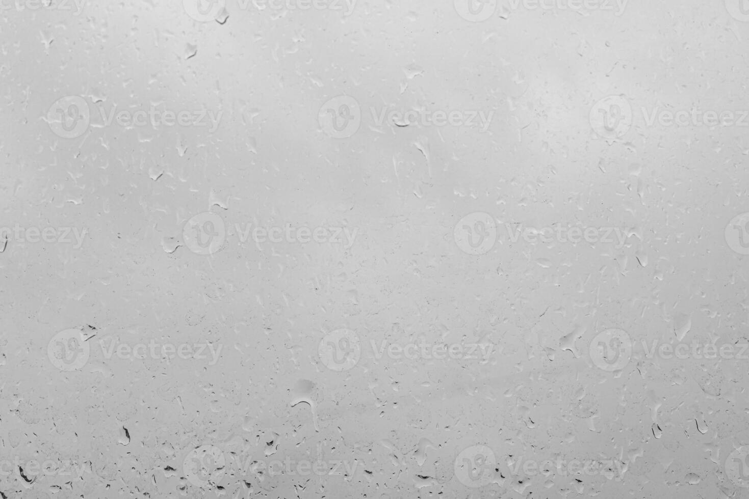 Rain drops on a window create a texture. Transparent liquid element for background or overlay effect concept on a gray surface. photo