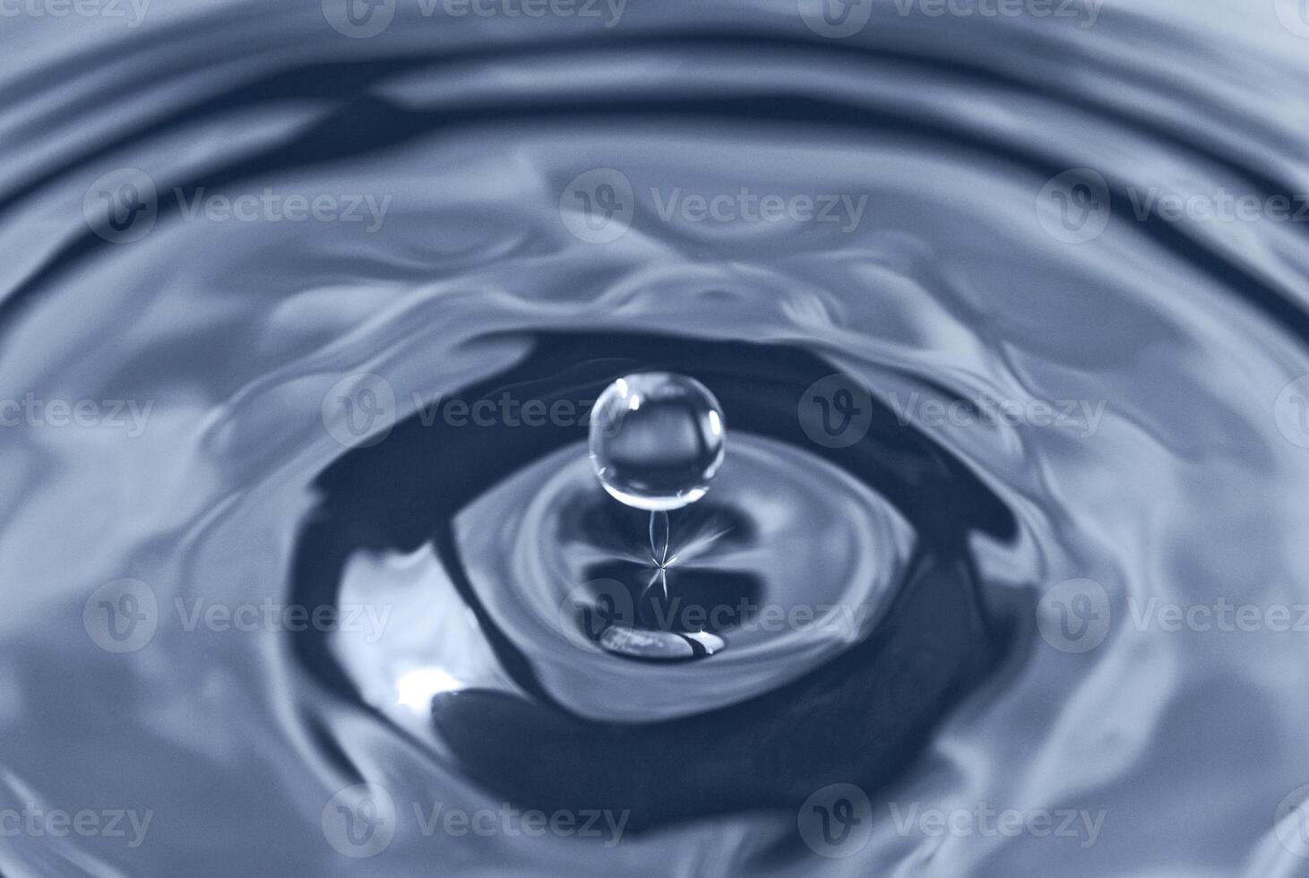 Splash from falling drop into water photo