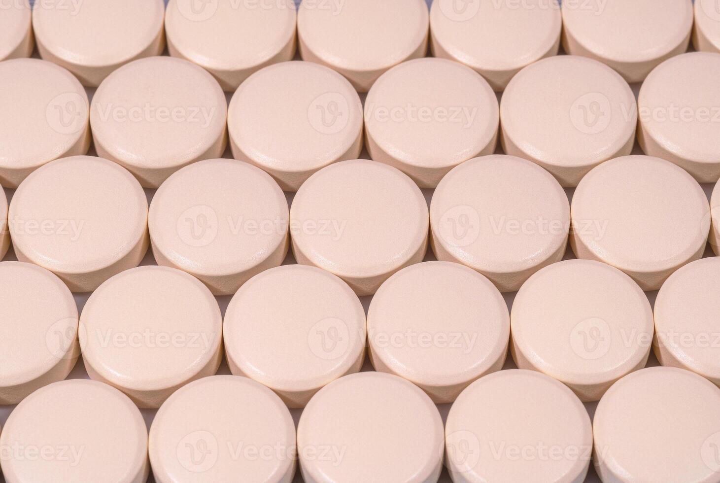 Rows of creamy color tablets close up photo