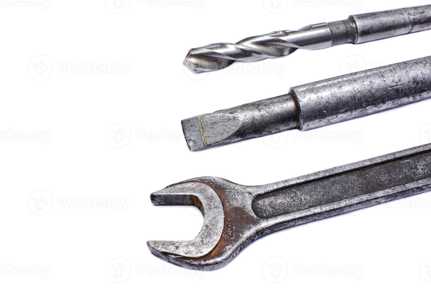 Shabby spanner, chisel and drill on white background photo