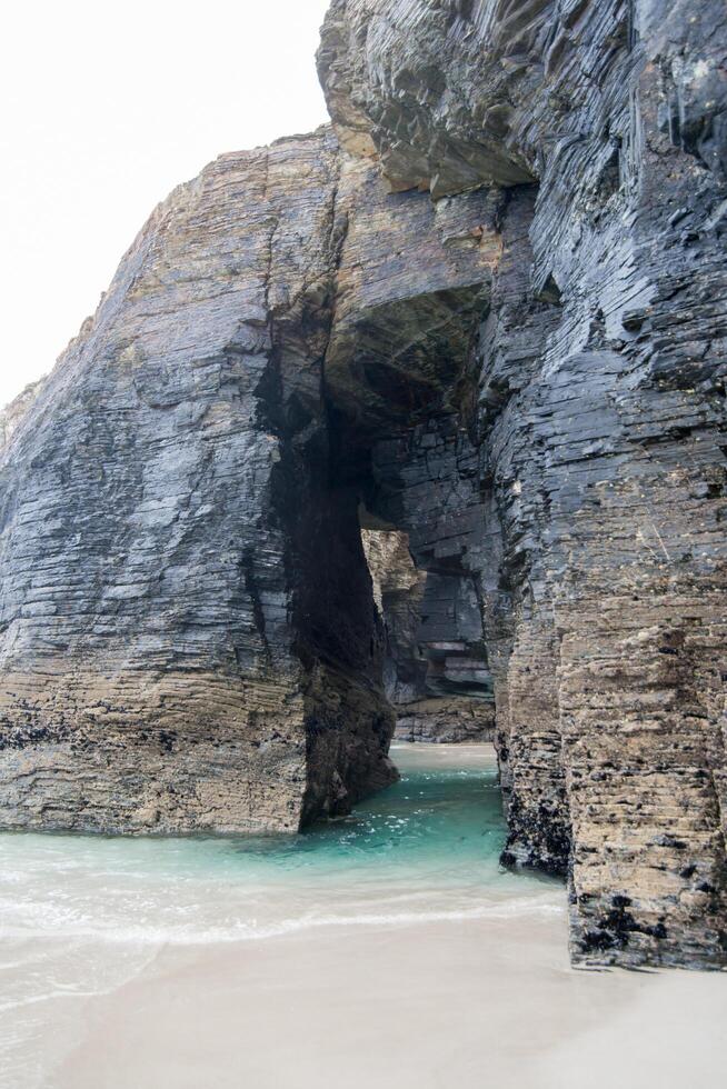 Cave with transparent water at Cathedrals beach. Lugo, Galizia, Spain photo