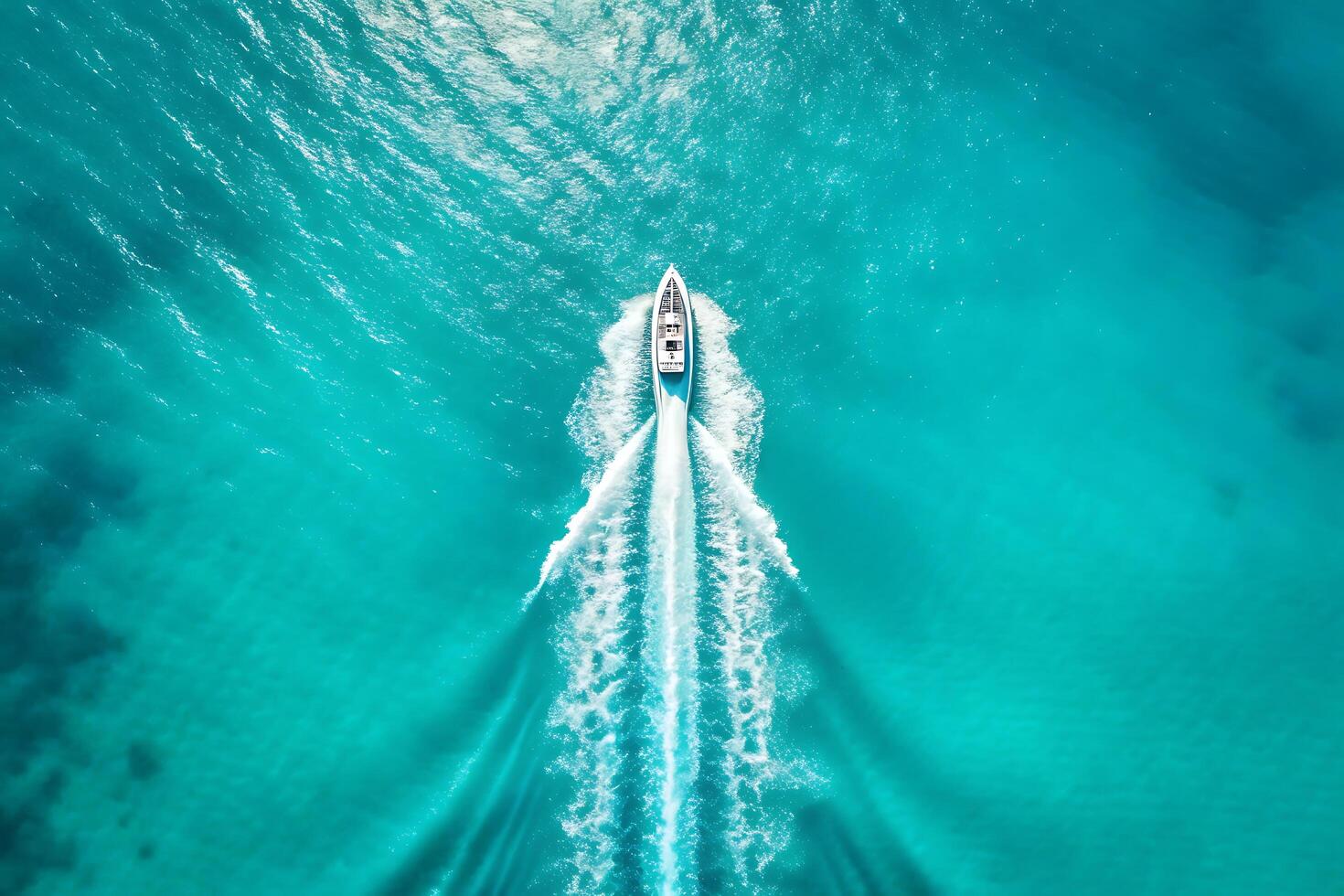 Aerial view of a speedboat racing through turquoise tropical ocean waters photo