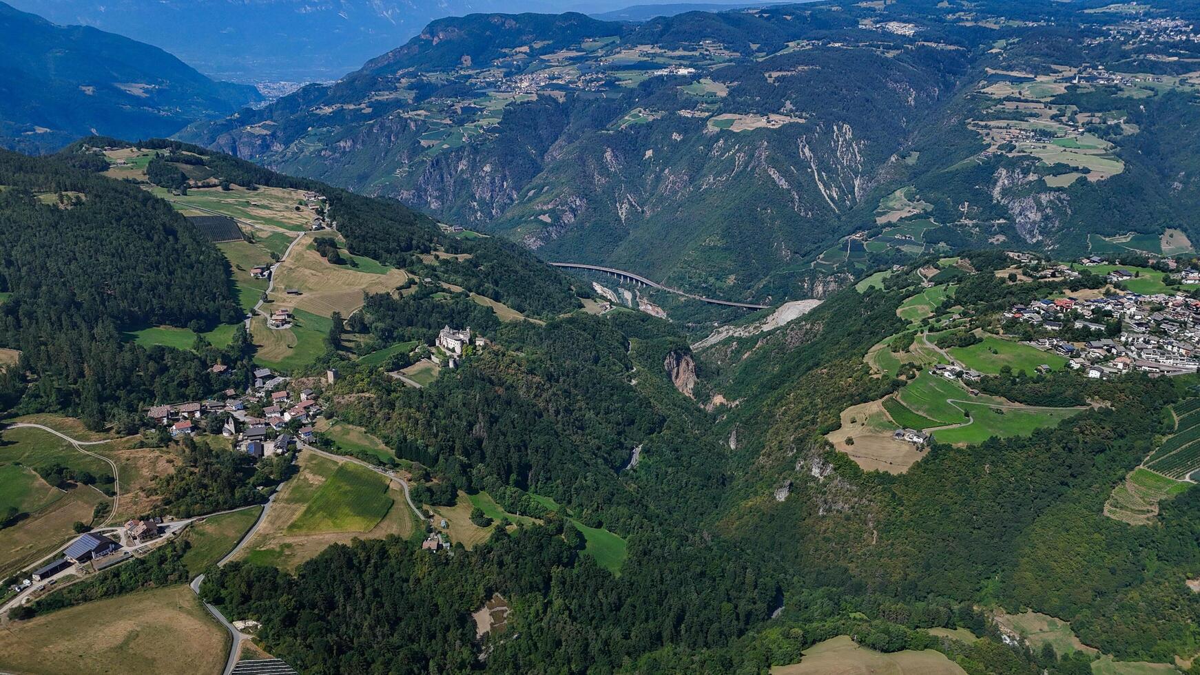 Majestic mountain valleys and charming villages nestled in the Northern Italy landscape during a serene summer afternoon photo