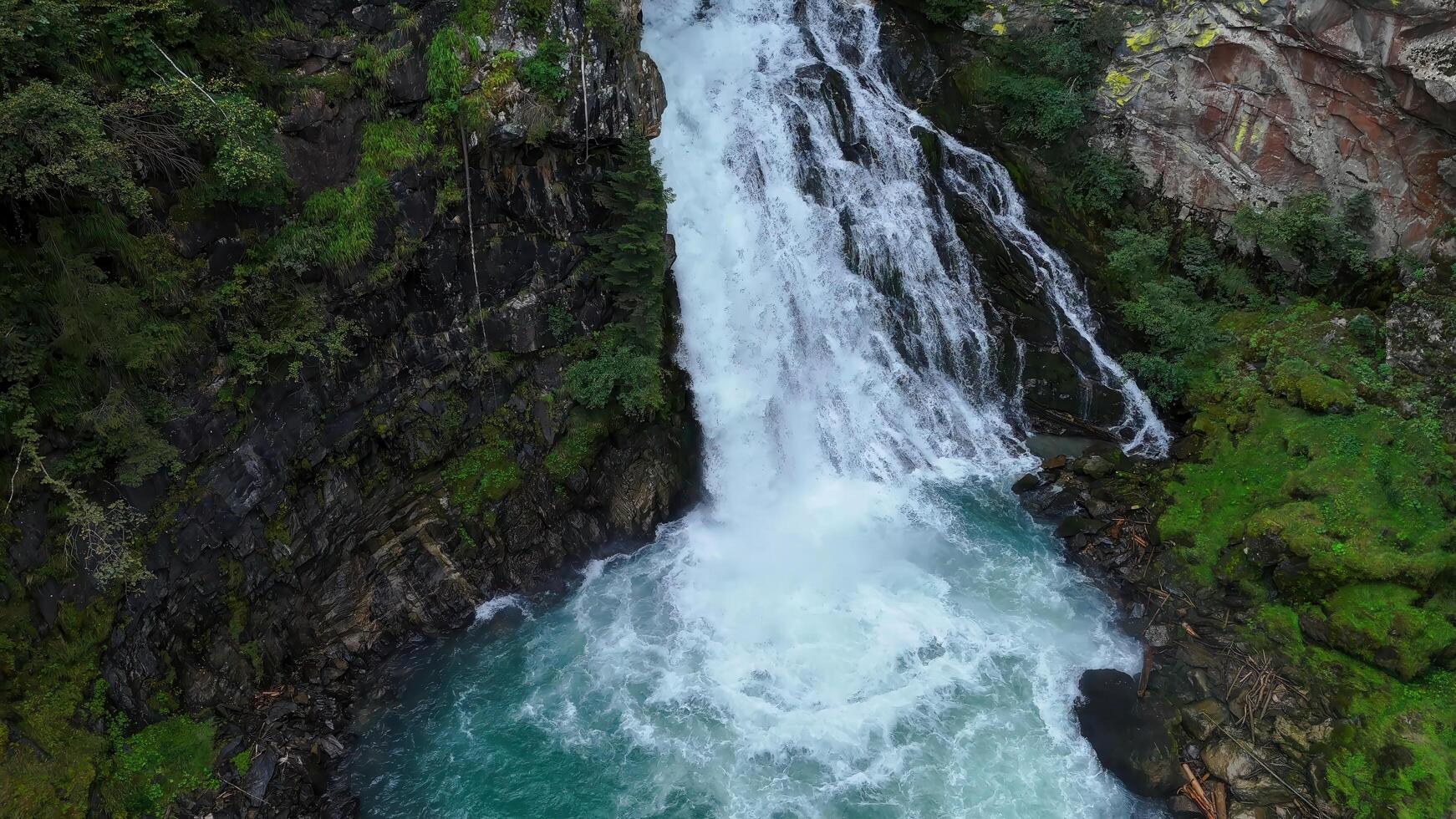Majestic waterfall cascading down rocky cliffs in a serene forest landscape under bright sunlight photo