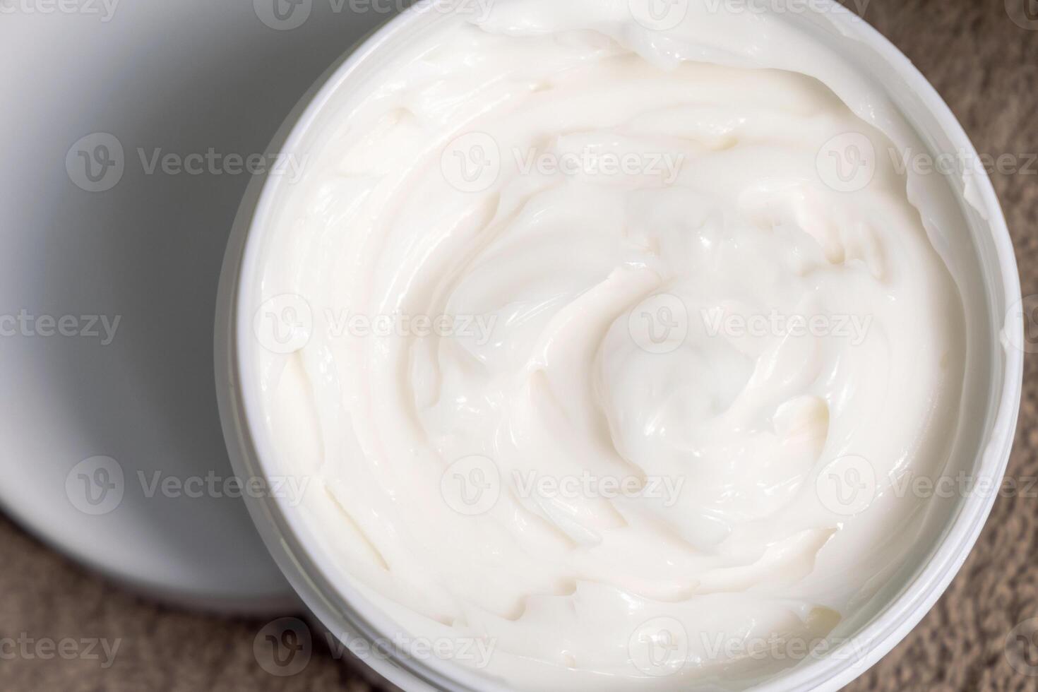Opened Jar of face or body cream on brown towel top view, Lotion in Opened cosmetic Container photo