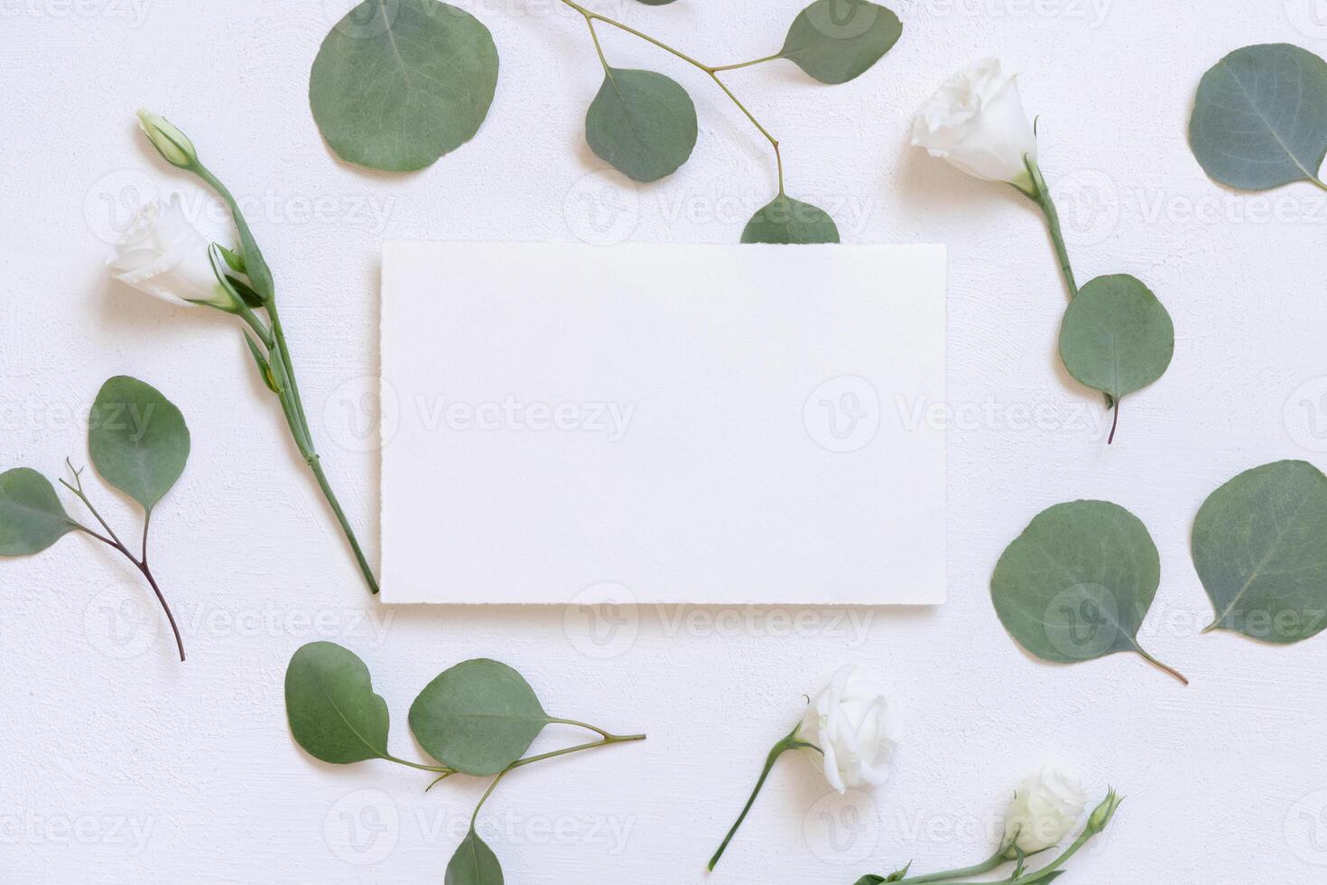 Card on a white table near flowers and green eucalyptus twigs, Wedding mockup photo